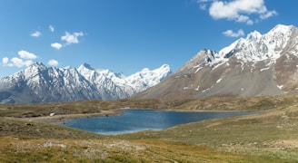 A bird's-eye view of a serene landscape with mountains and lakes under clear skies.