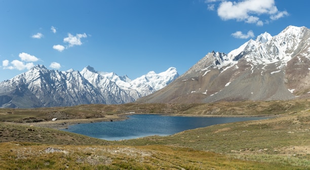 A bird's-eye view of a serene landscape with mountains and lakes under clear skies.