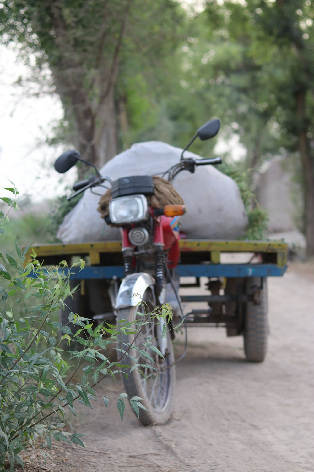 a motorcycle with a trailer attached to it on a dirt road