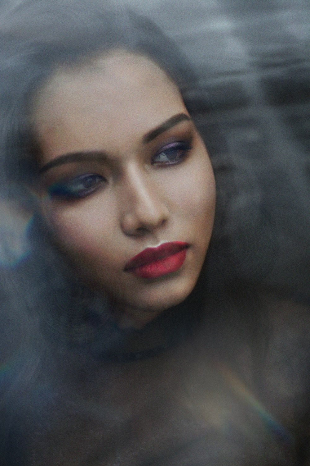 a woman with red lipstick and blue eyes