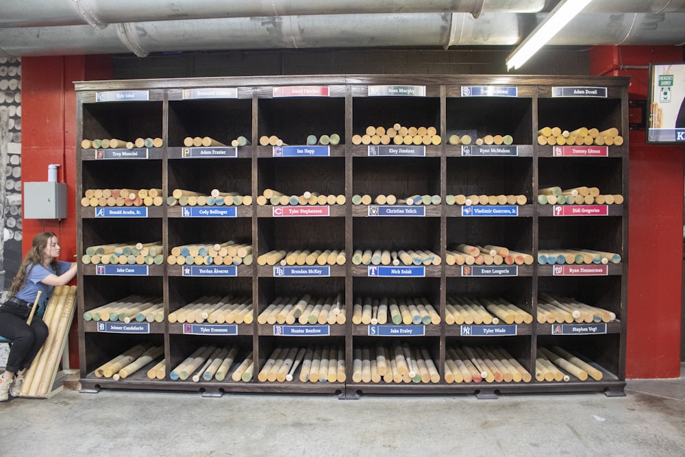 a woman sitting on a bench in front of a display of food