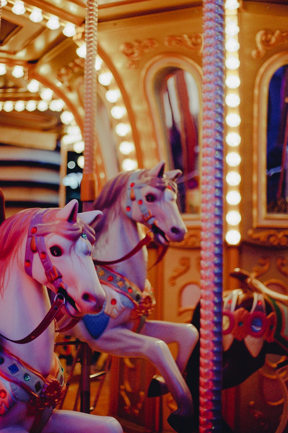 a couple of white horses on a merry go round