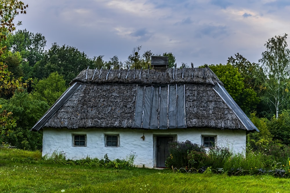 a small white house with a thatched roof