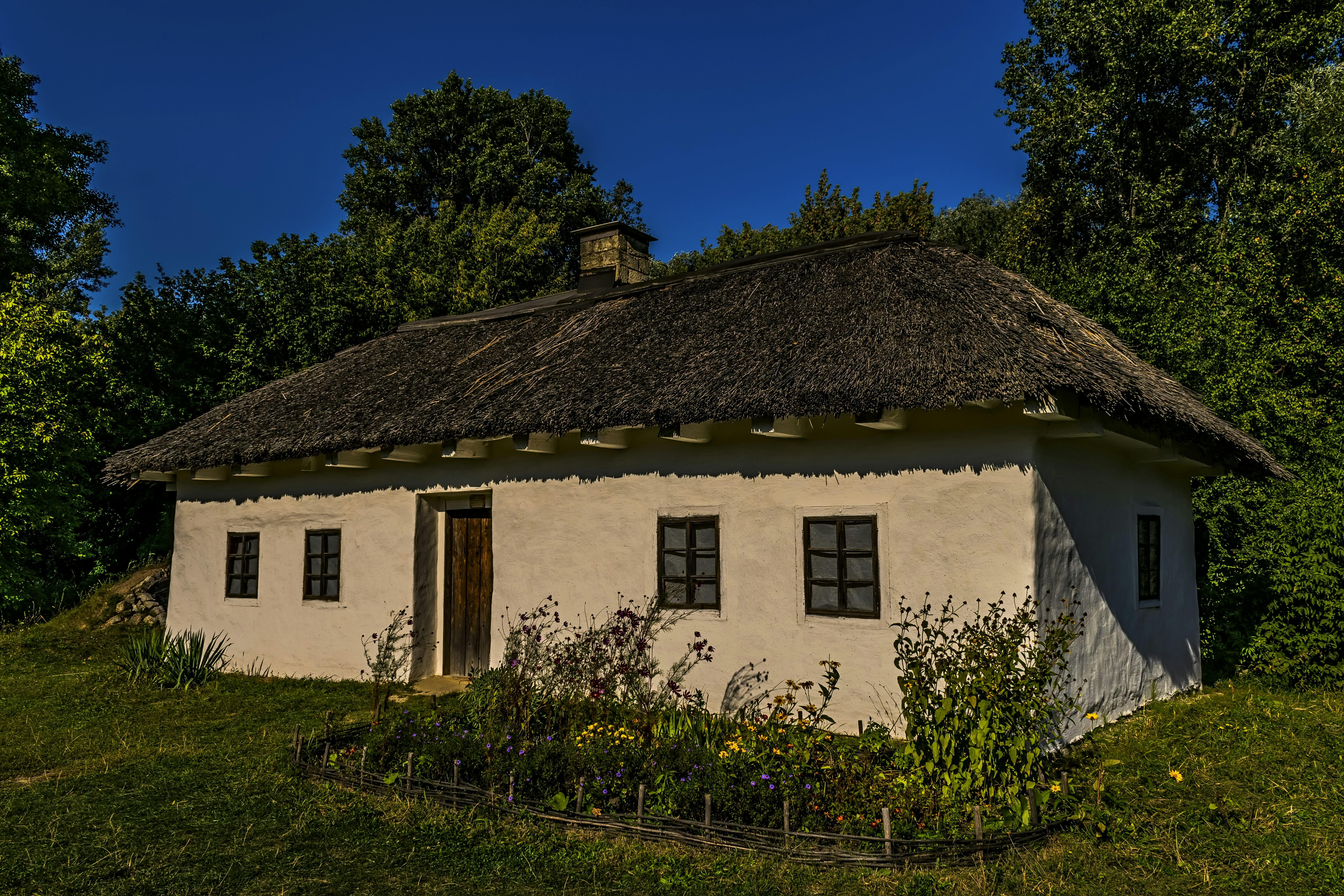 a small white house with a thatched roof