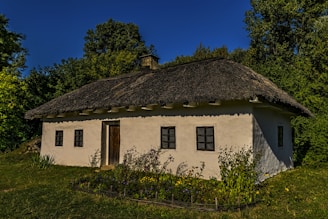 a small white house with a thatched roof