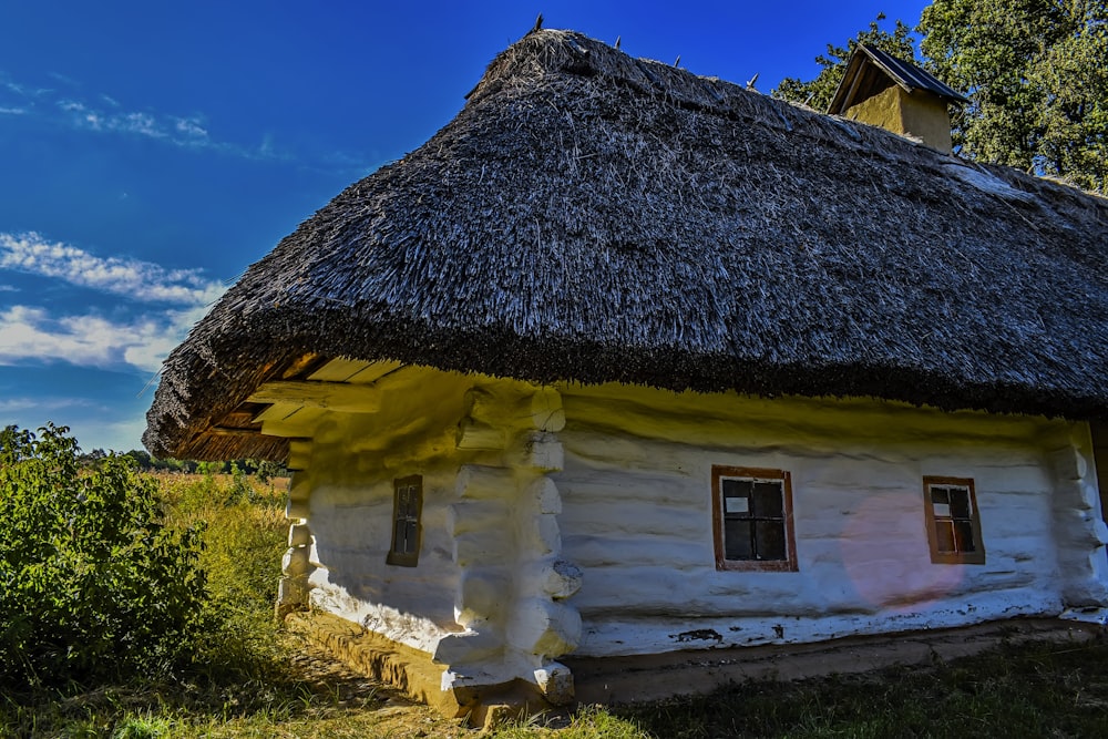 an old log house with a thatched roof