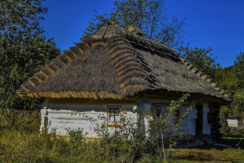 a small white house with a thatched roof