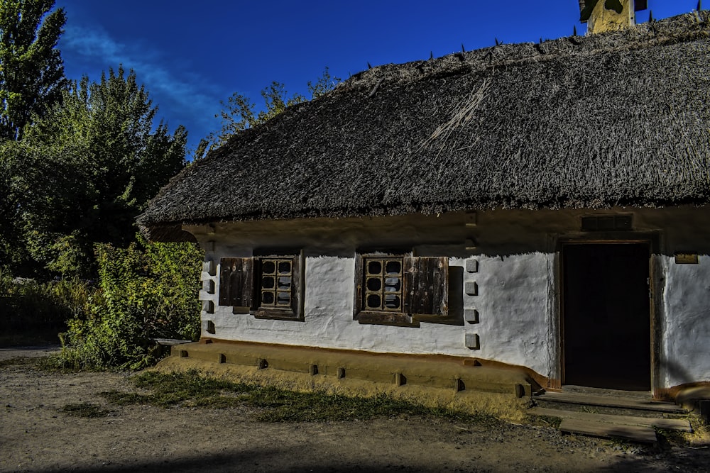a white house with a thatched roof and windows