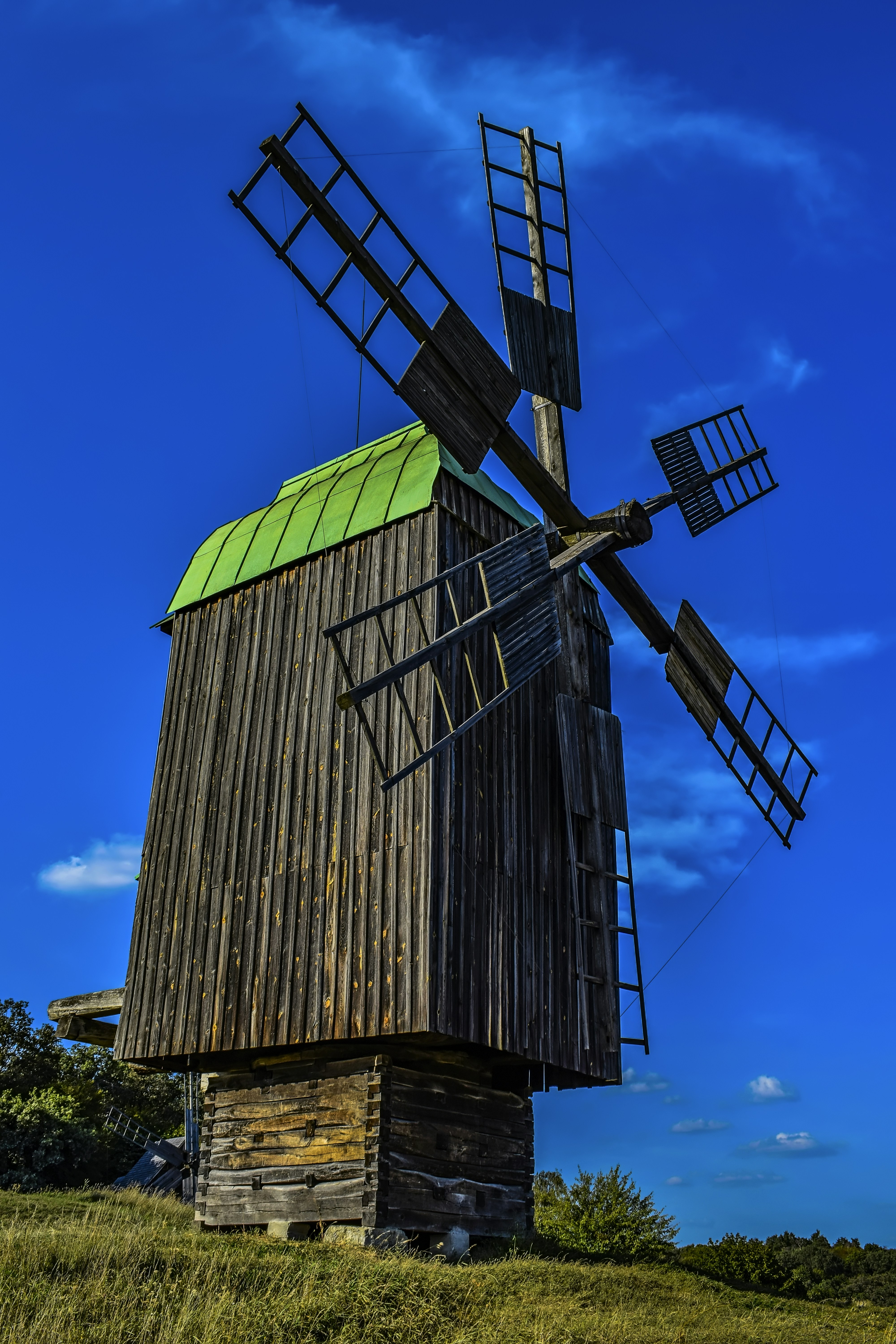 an old wooden windmill with a green roof