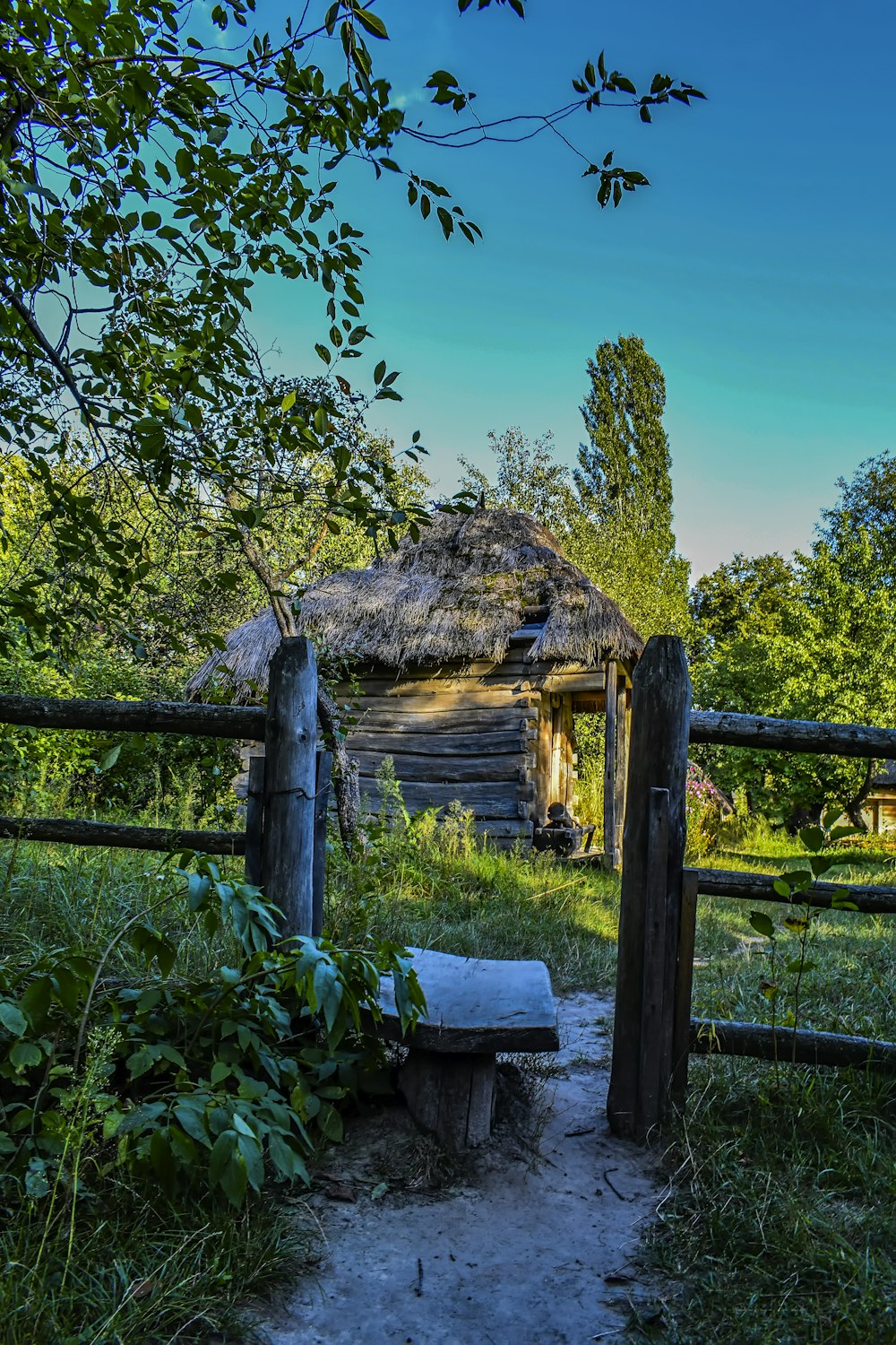 an old log cabin with a thatched roof