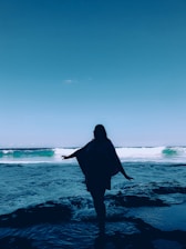 a person standing in the water with a surfboard