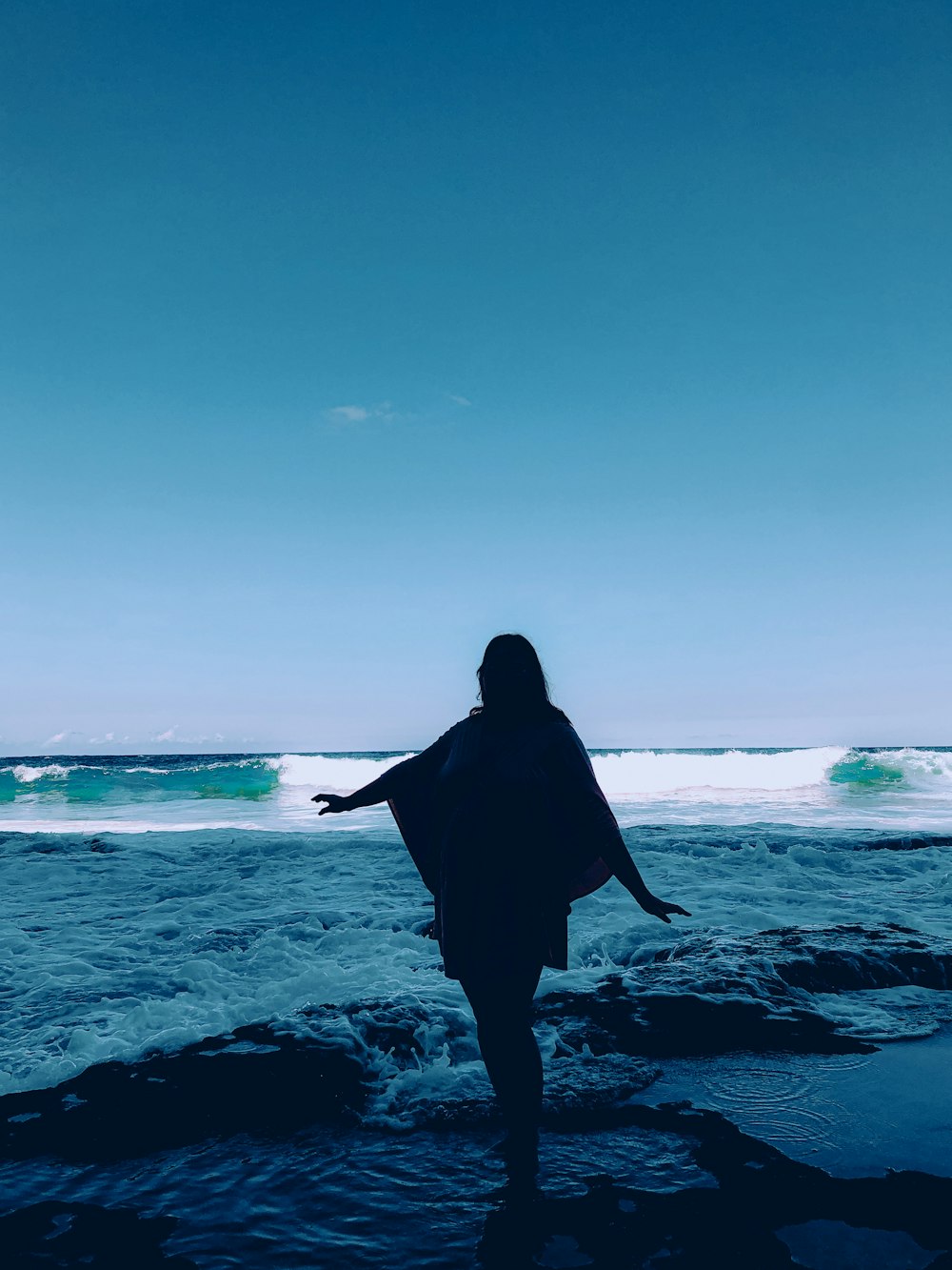 a person standing in the water with a surfboard