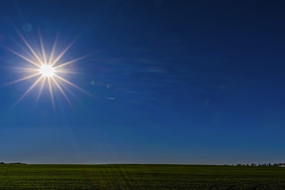 the sun is shining brightly over a green field