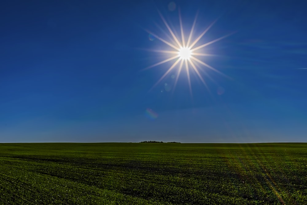 the sun shines brightly over a green field