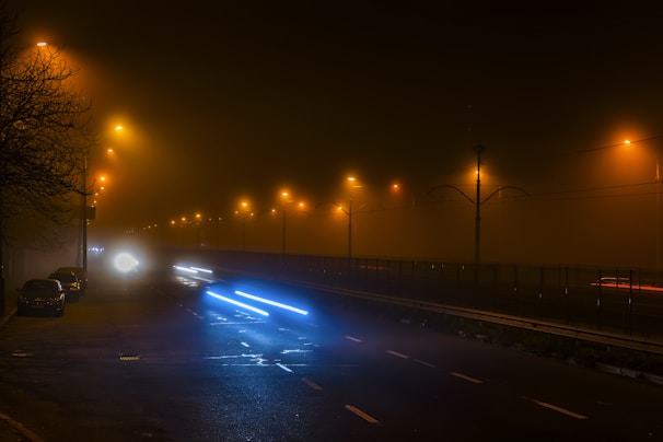 A foggy streetlamp illuminating a deserted street at night.