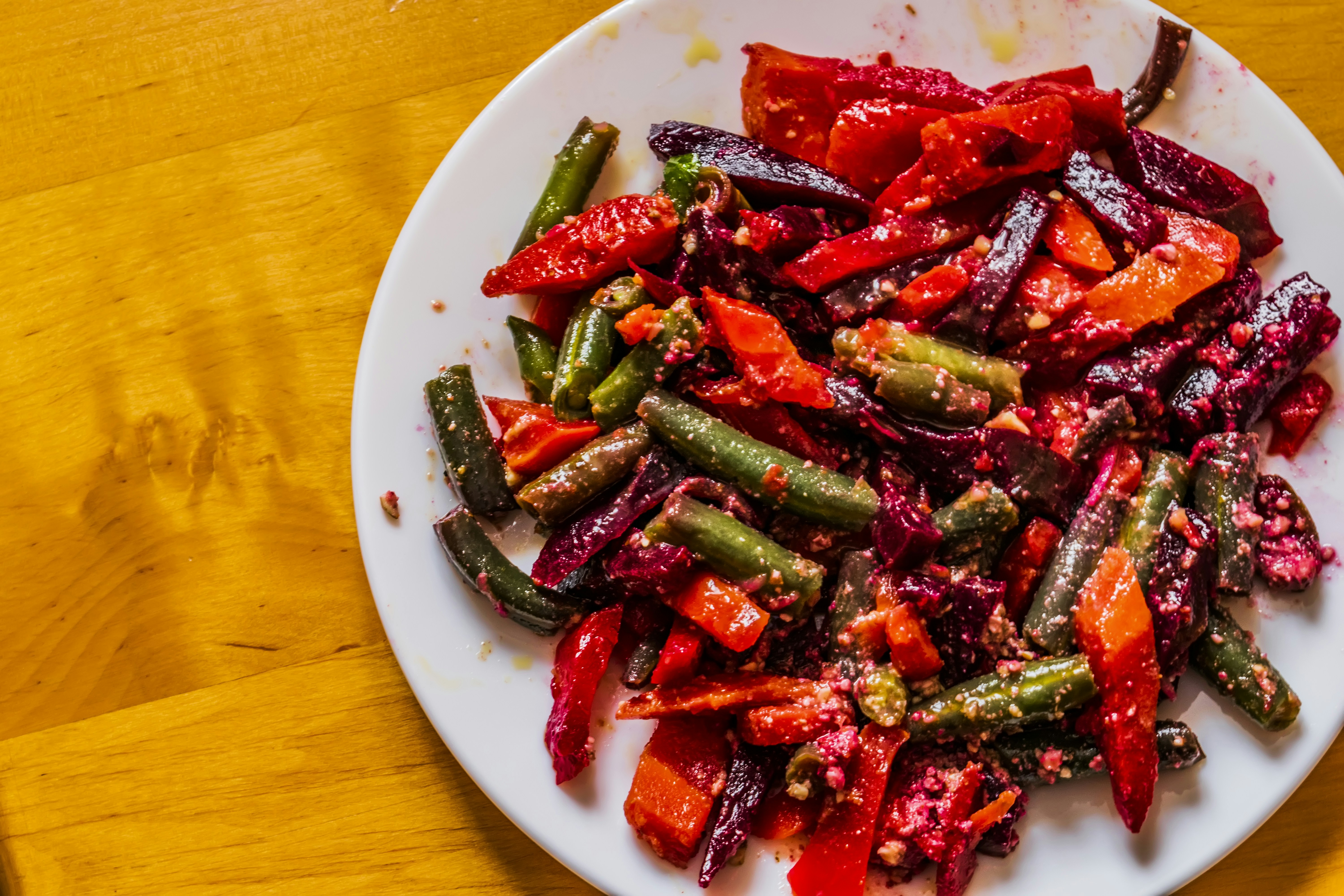 a white plate topped with red and green vegetables