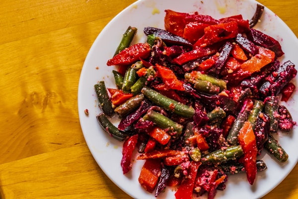 A white plate topped with red and green vegetables