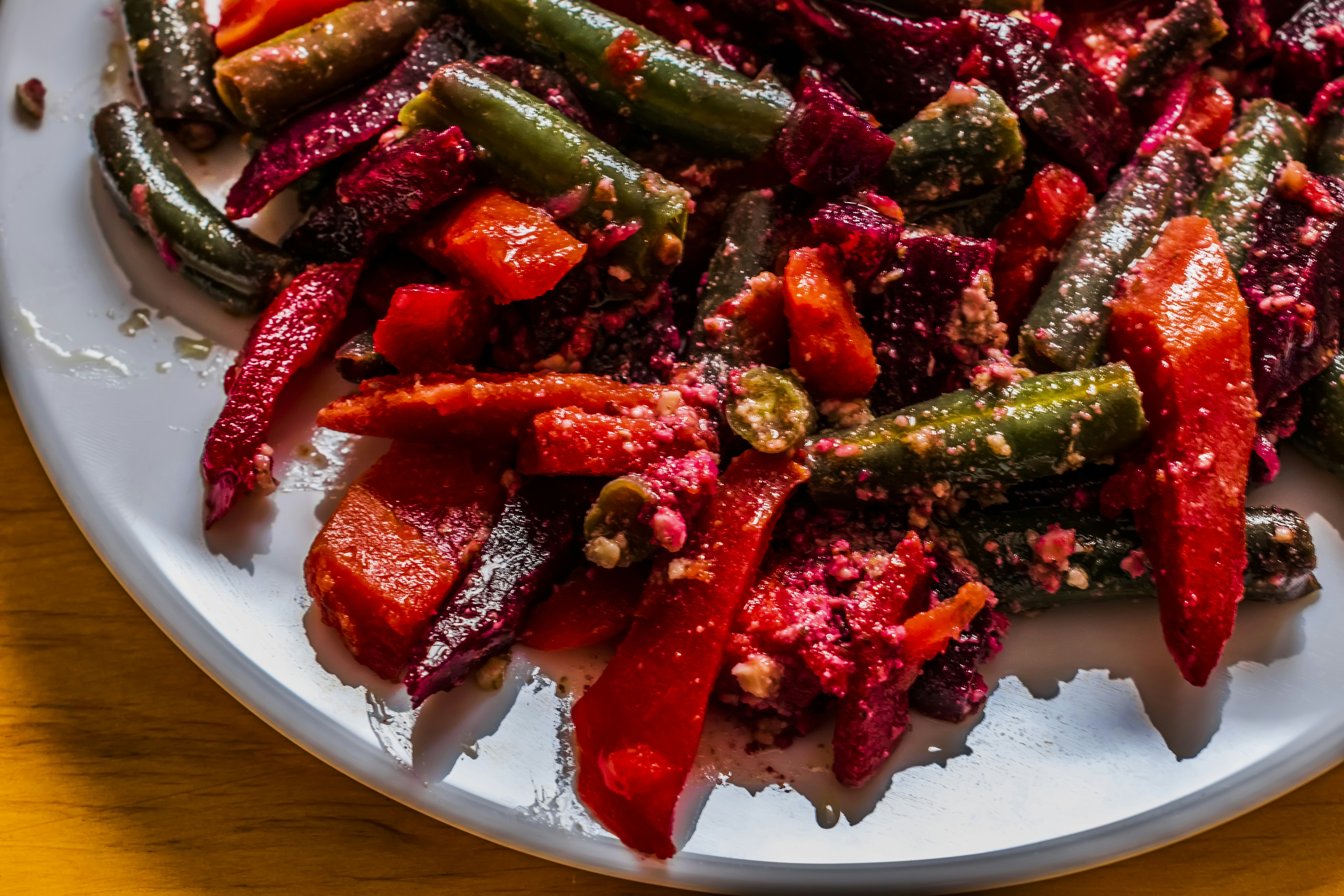a white plate topped with red and green vegetables