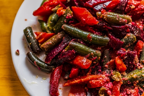 A white plate topped with red and green vegetables