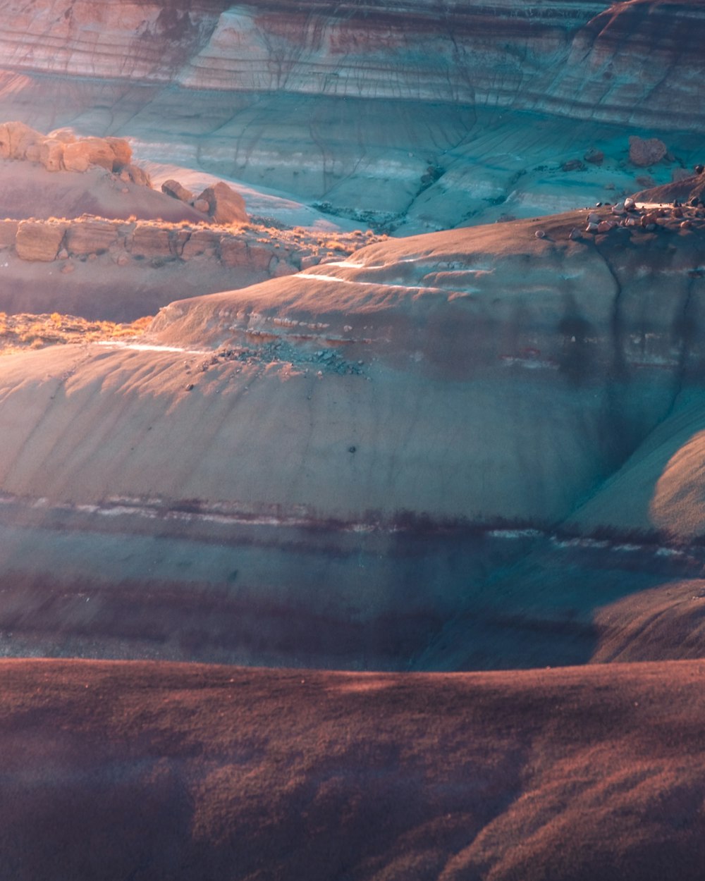 an aerial view of a mountain range with snow on the ground