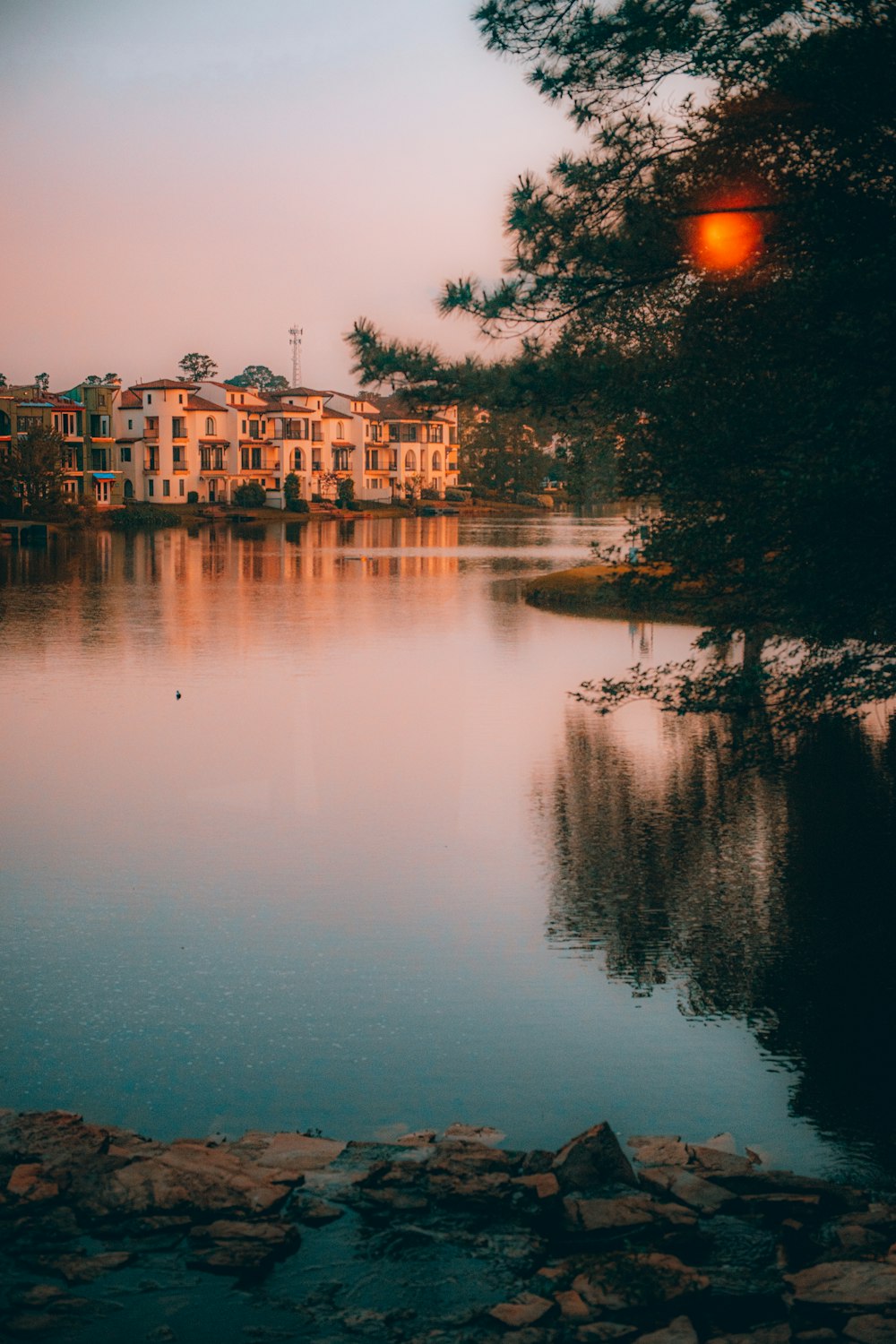 a body of water surrounded by trees and buildings