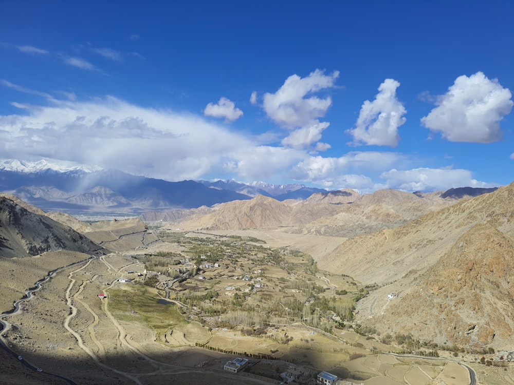 a scenic view of a valley with mountains in the background