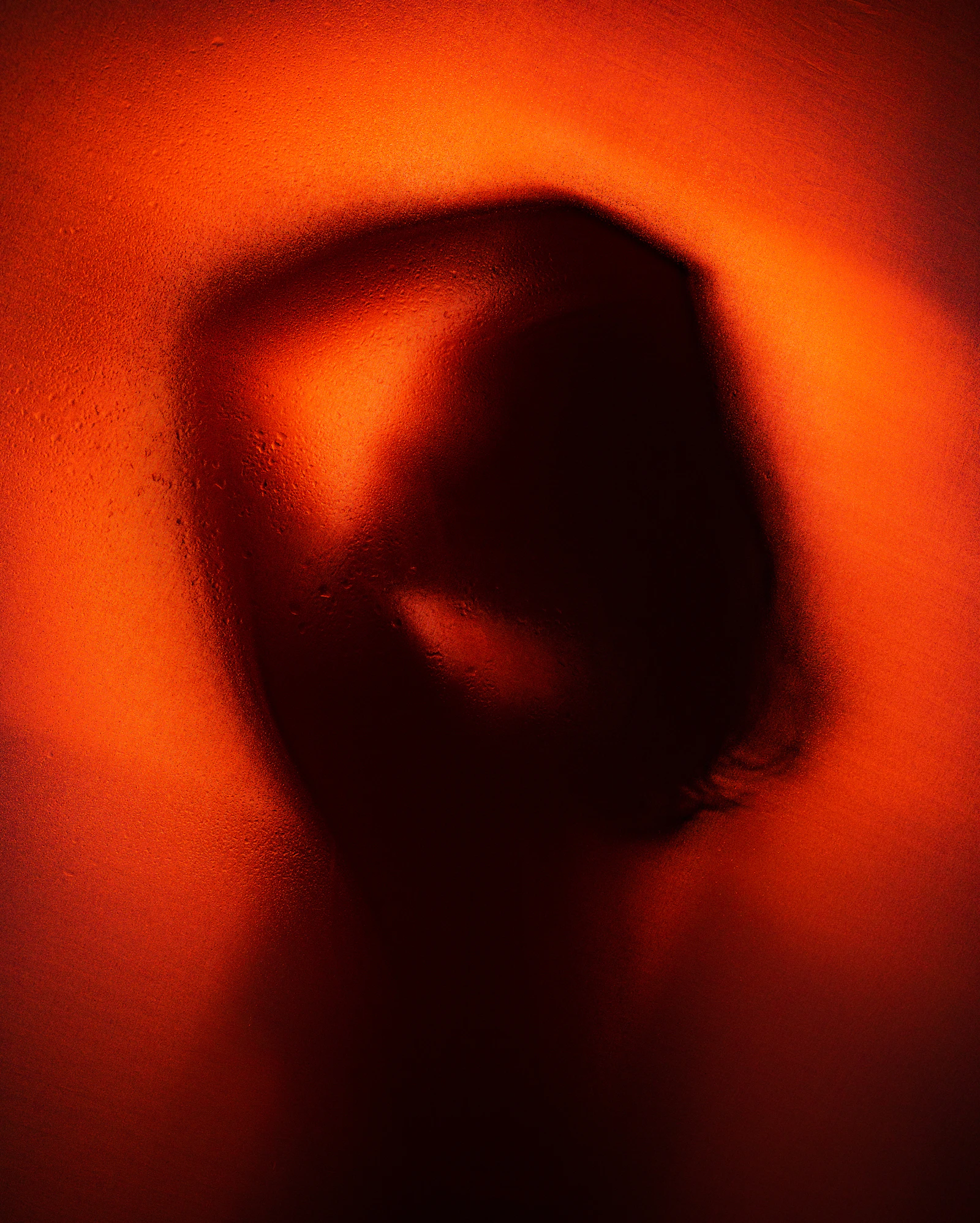 A figure's shadow on a warm orange wall