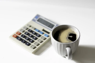 a cup of coffee next to a calculator