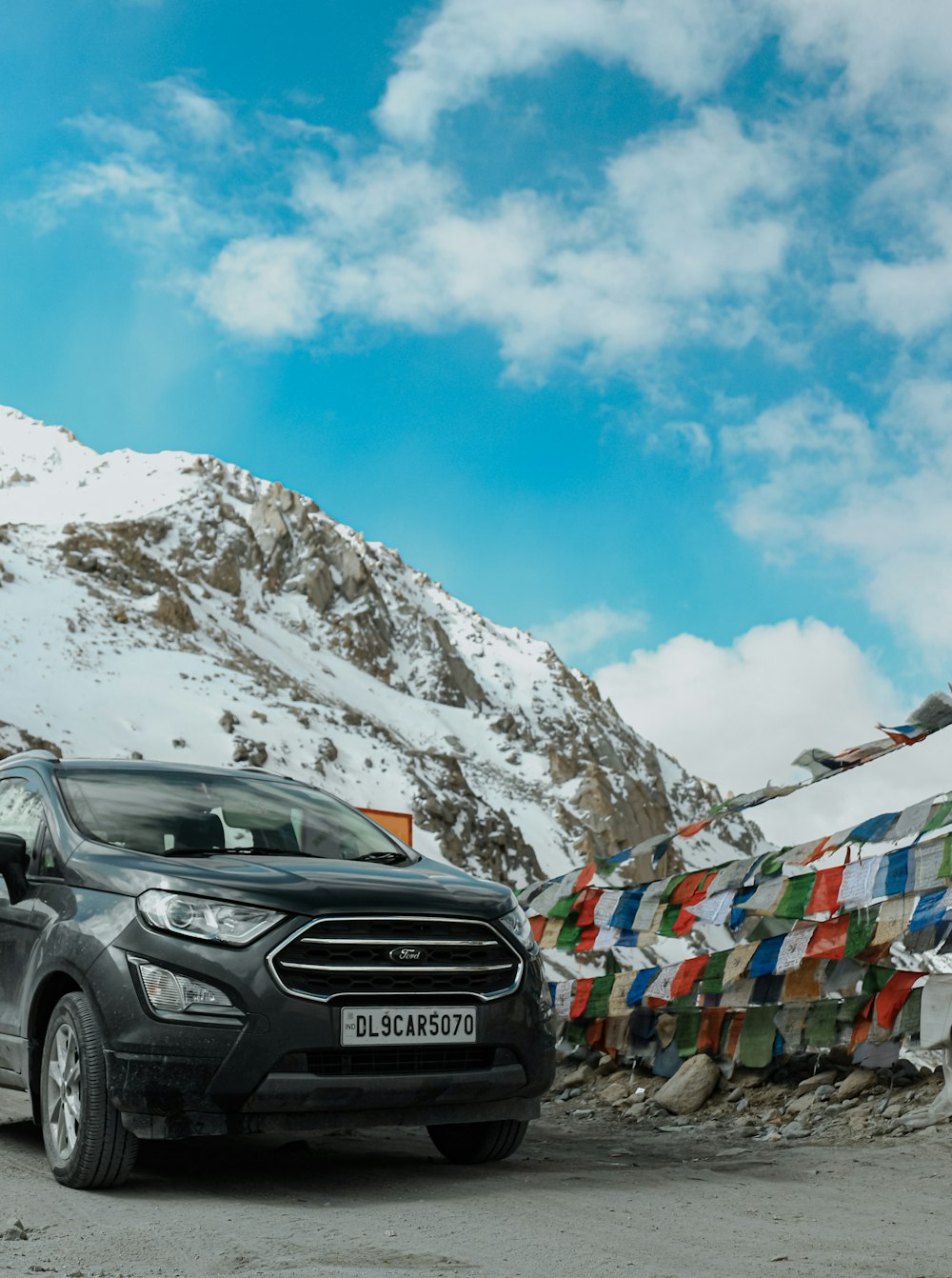 a black car parked in front of a mountain