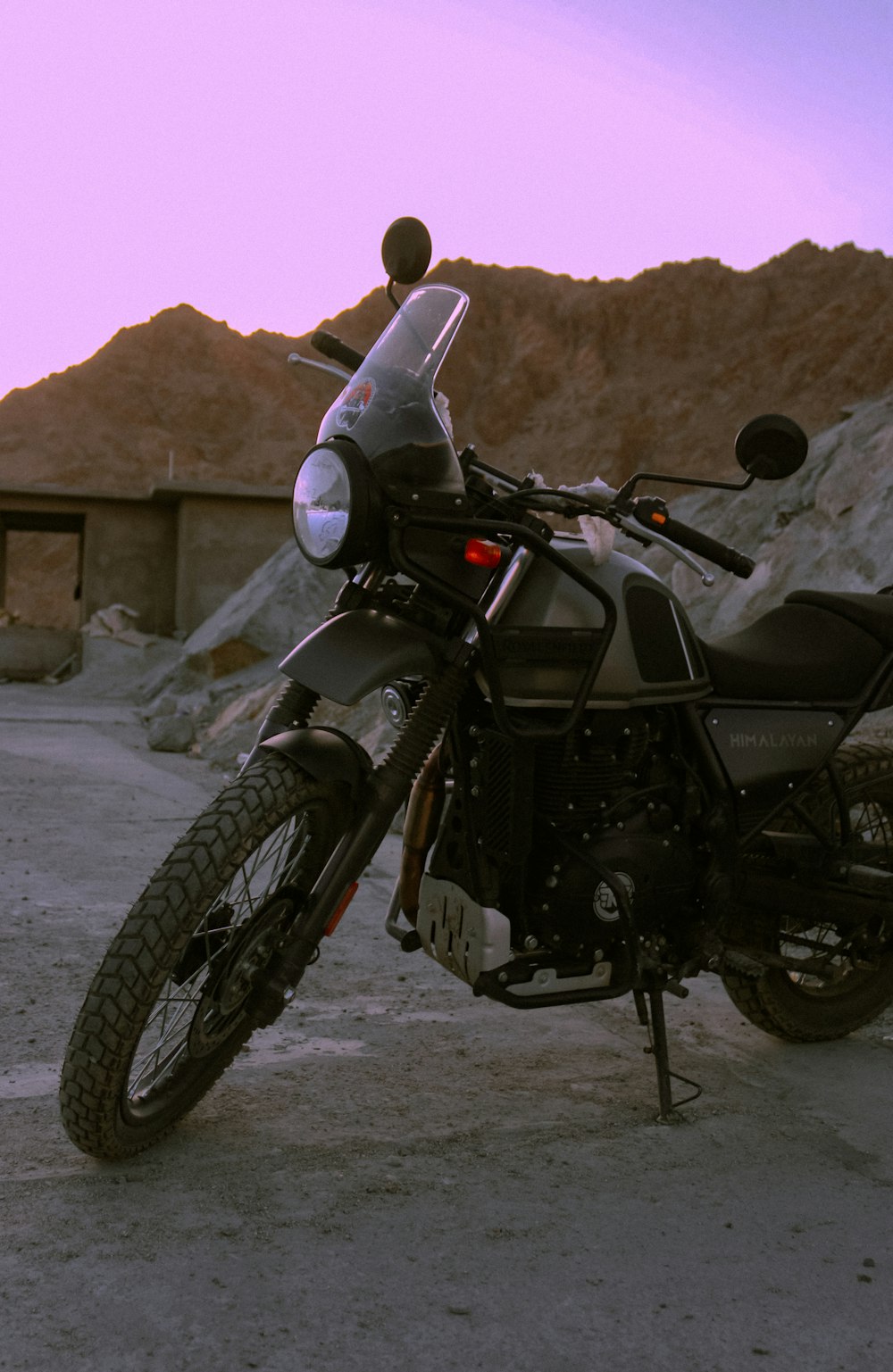 uma motocicleta estacionada em um estacionamento com montanhas ao fundo