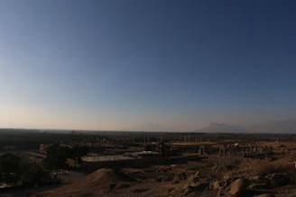 A vibrant fantasy landscape with a hero exploring an ancient ruin under a glowing sunset.