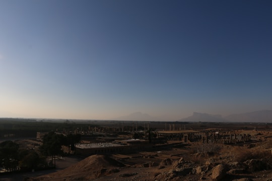 An epic landscape from an adventure game showing a hero exploring mystical ruins under a sunset sky.