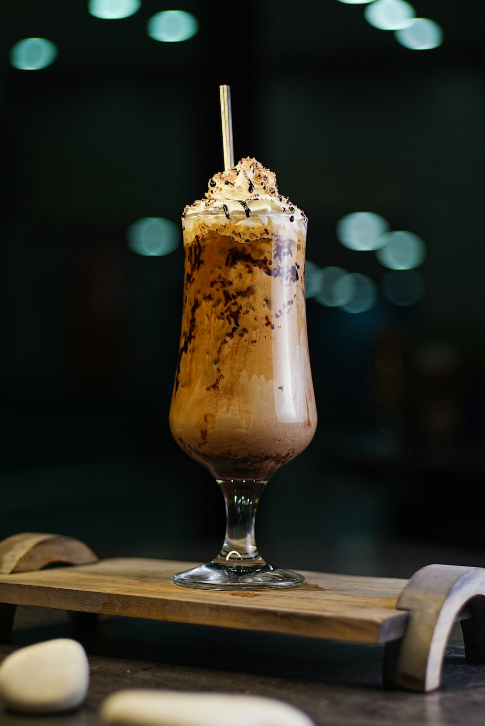 a chocolate milkshake sitting on top of a wooden board