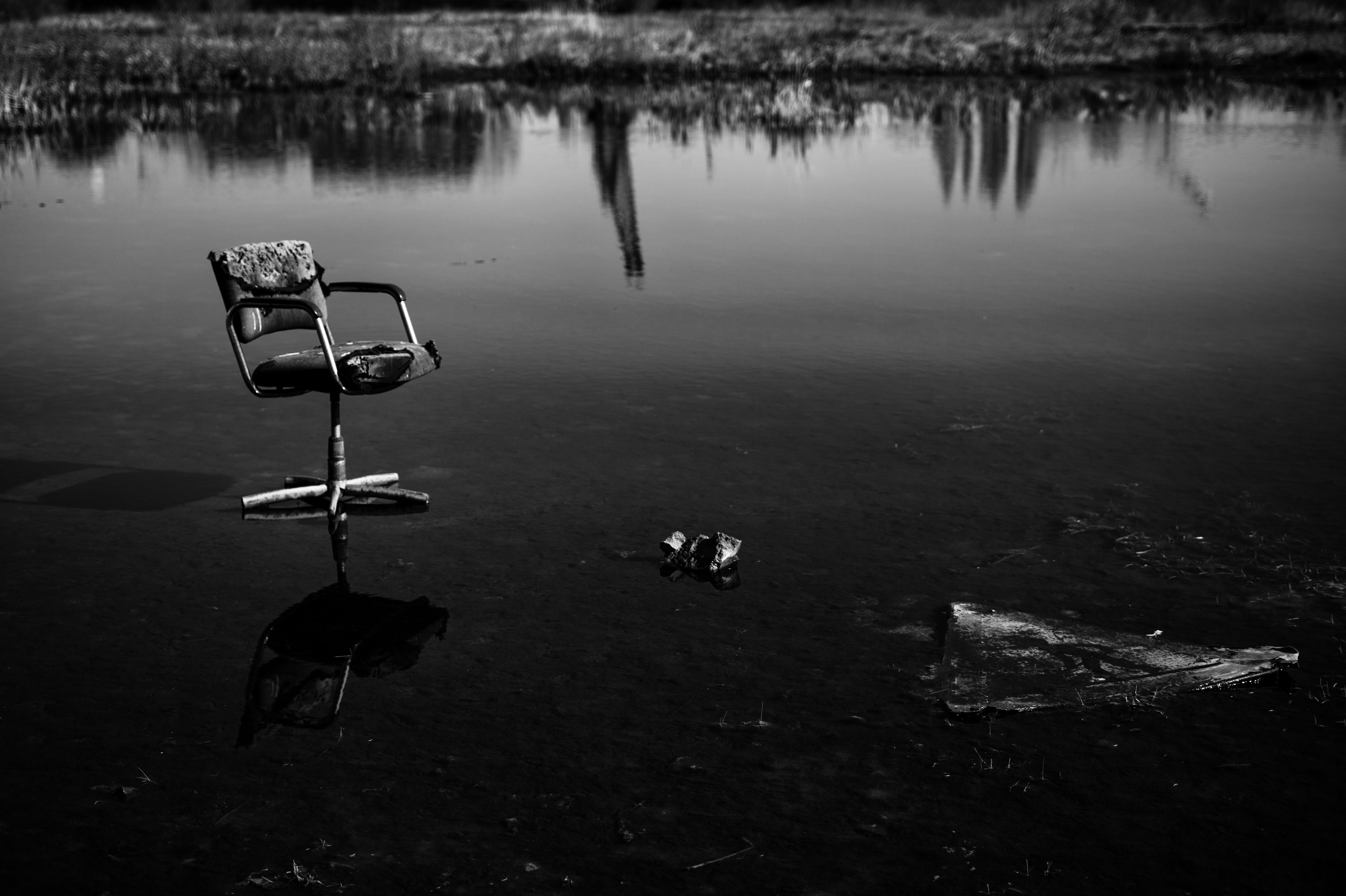 A chair sitting in the middle of a body of water photo Free Grey Image on Unsplash