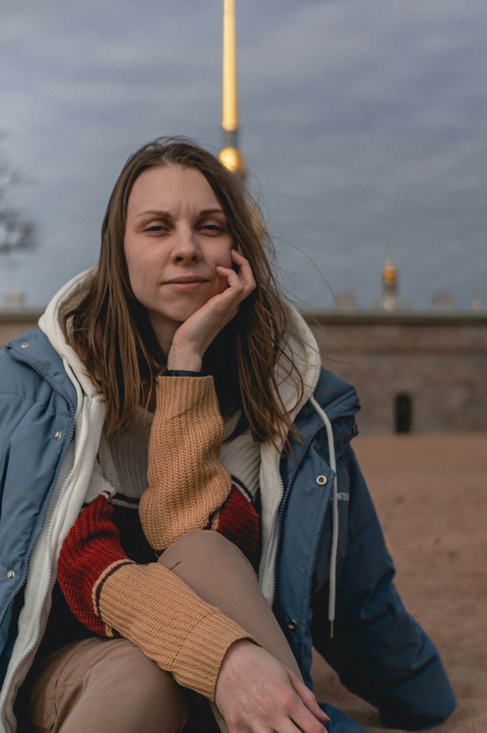 a woman sitting on the ground with her hand on her face