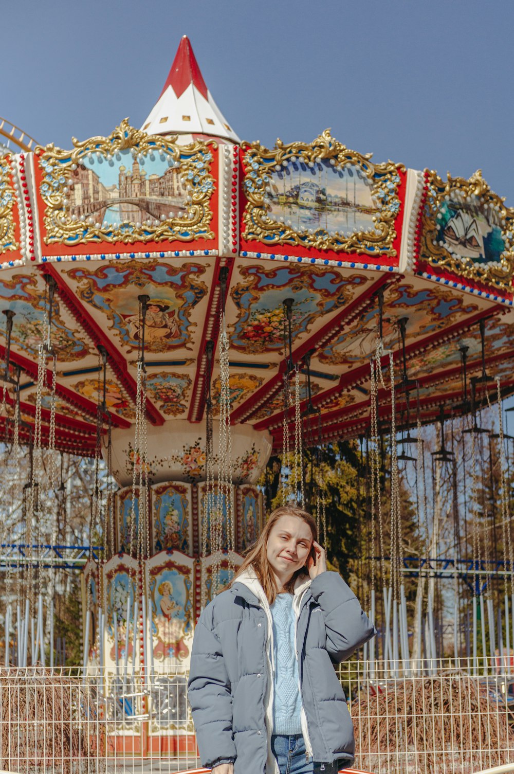 a woman standing in front of a merry go round