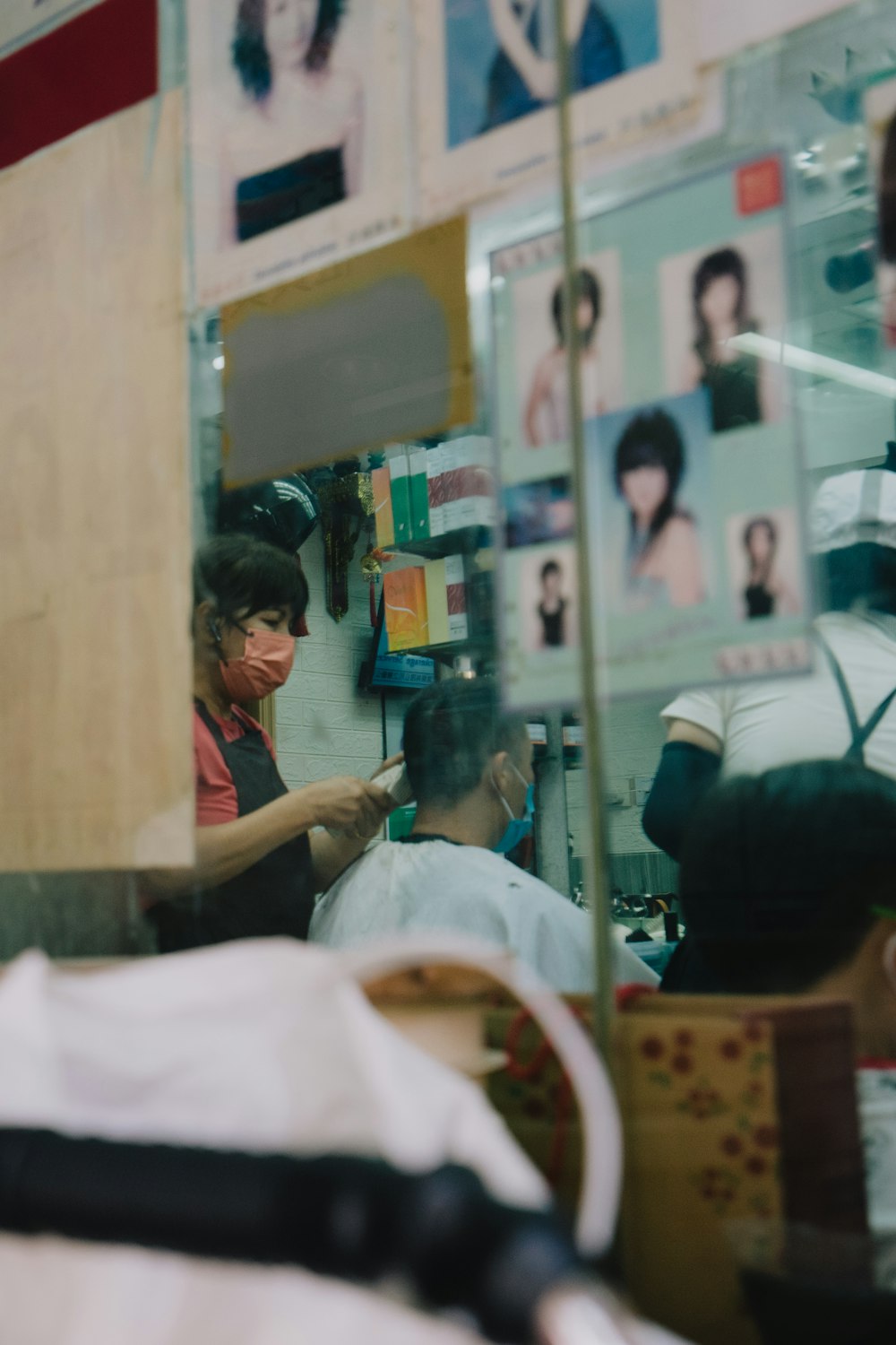 uma mulher cortando o cabelo de um homem em uma barbearia