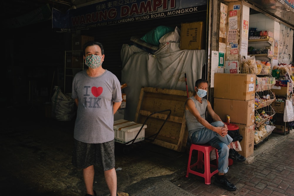 a man wearing a face mask standing in front of a store