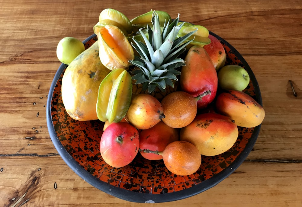 a bowl filled with fruit on top of a wooden table