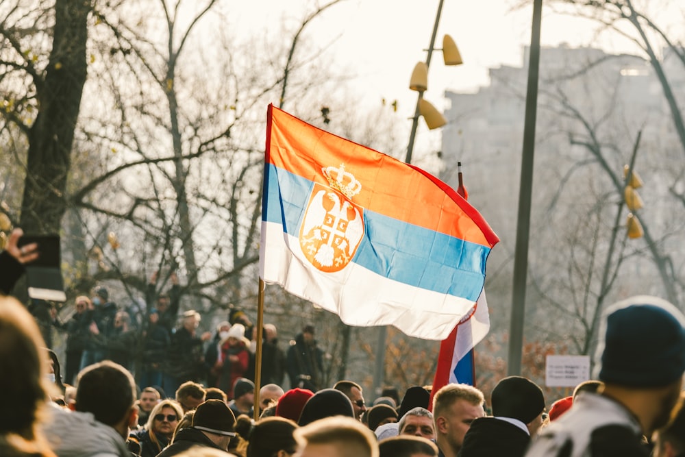 a crowd of people standing around a flag