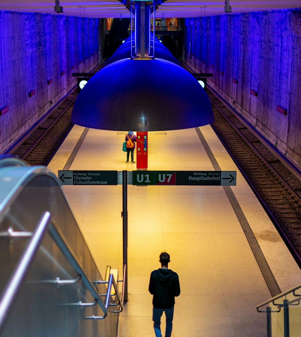 a man is walking down the escalator of a train station