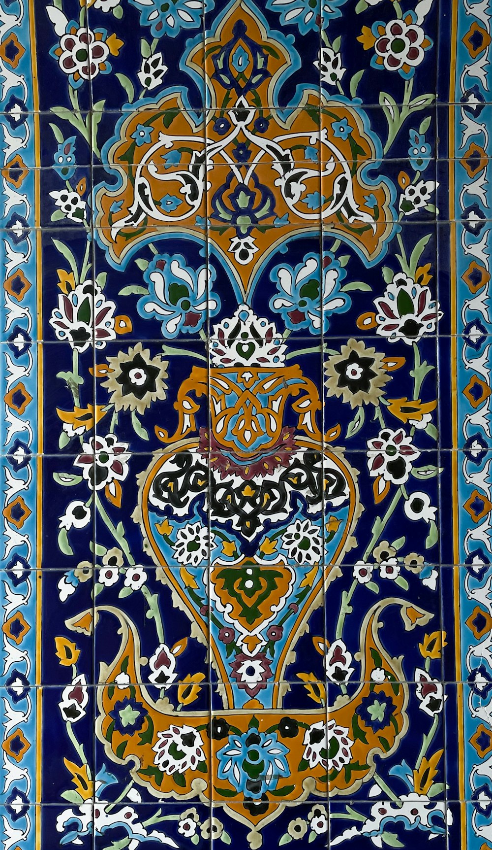 a blue and orange tile with a floral design