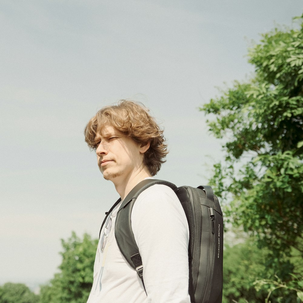 a man with a backpack standing in a field