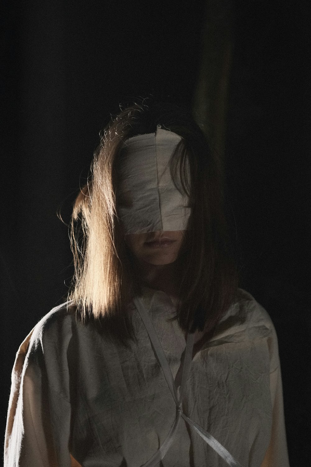 a woman with a bandaged head and a white shirt
