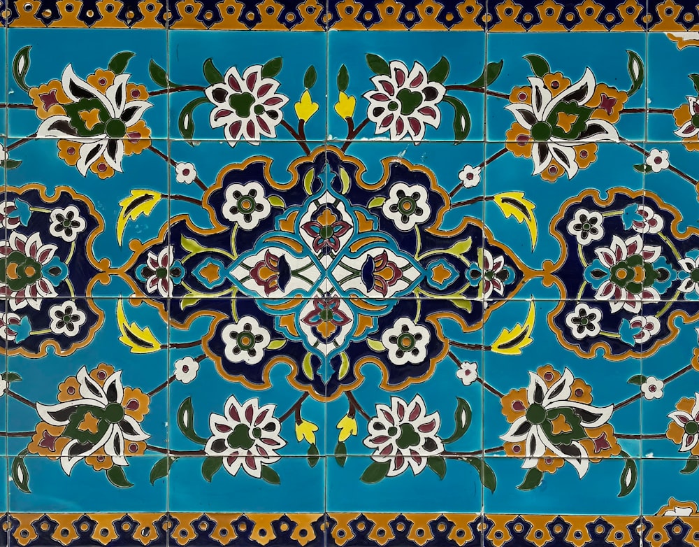 a blue and yellow tile with flowers on it