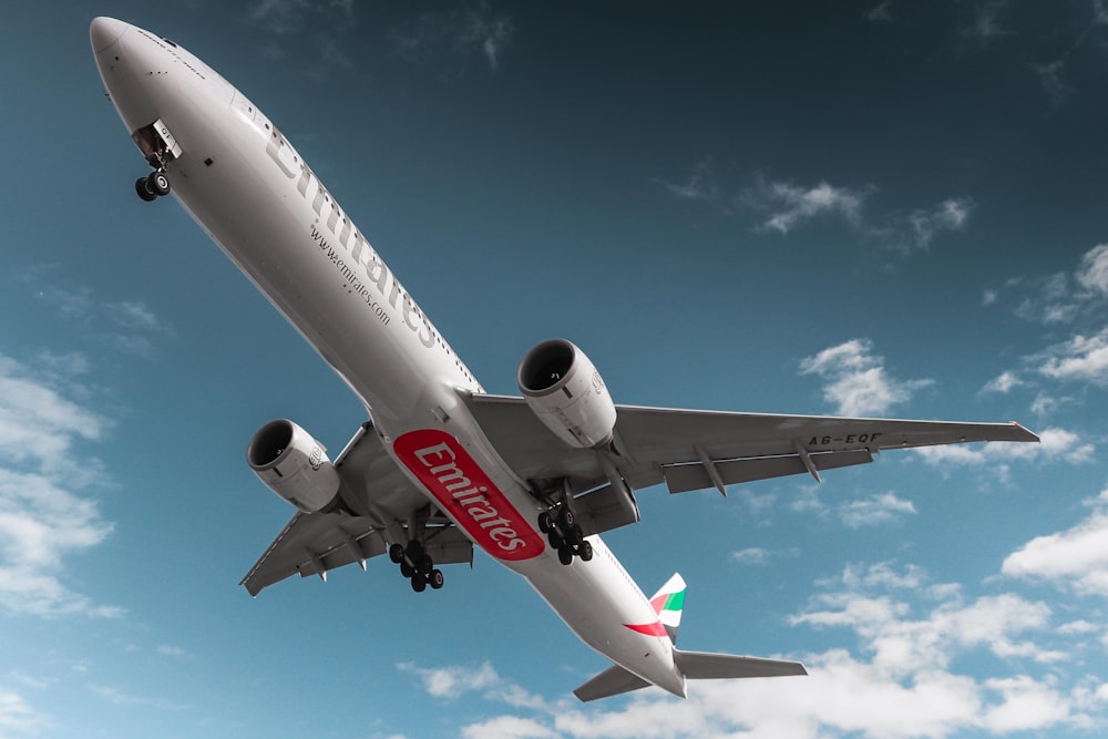 a large jetliner flying through a blue cloudy sky