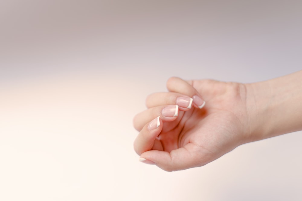 a woman's hand holding something in her left hand