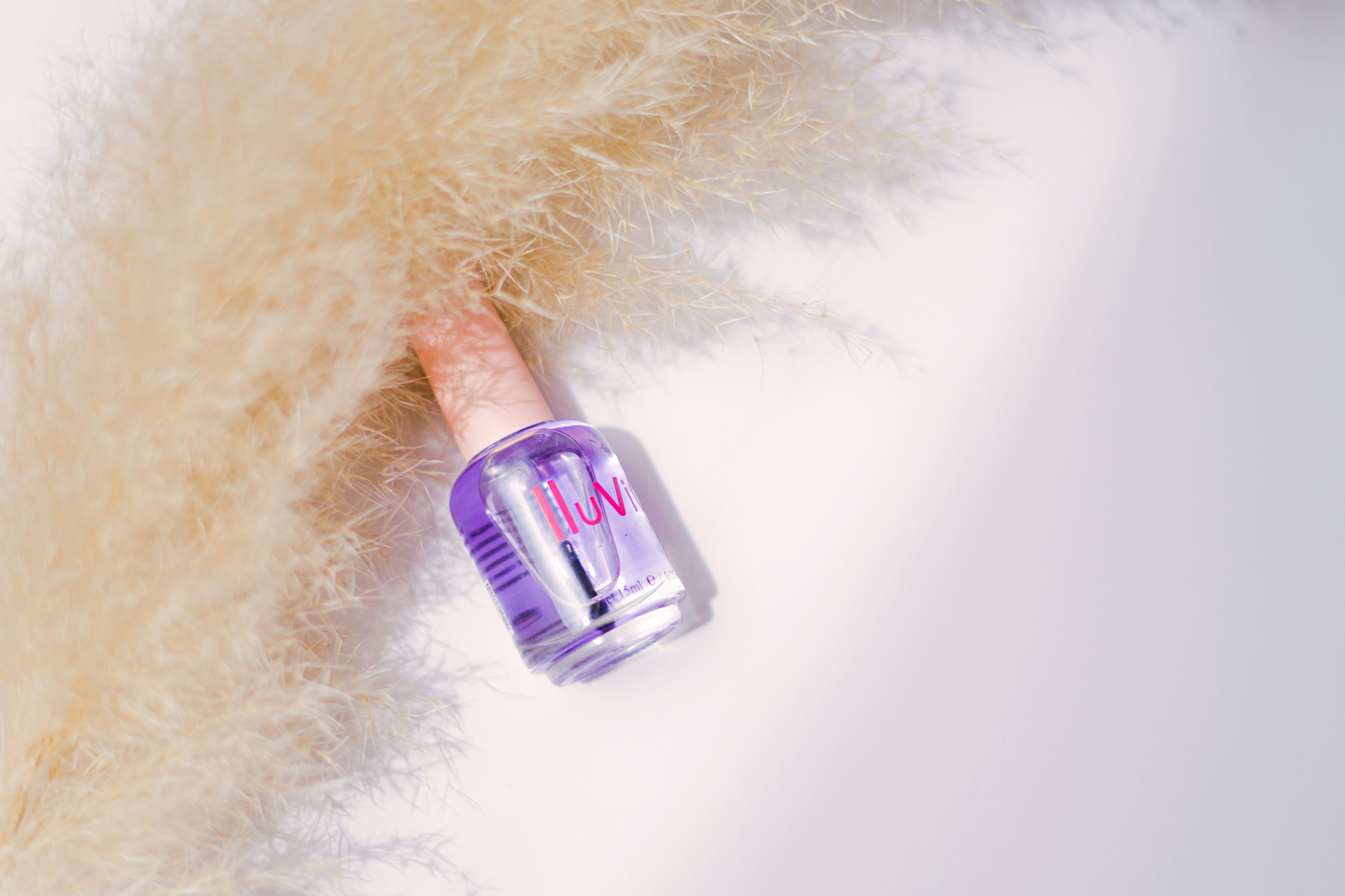a bottle of nail polish sitting on top of a pile of fur
