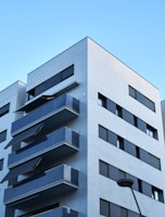 Modern apartment building exterior in Mbour with blue night sky.