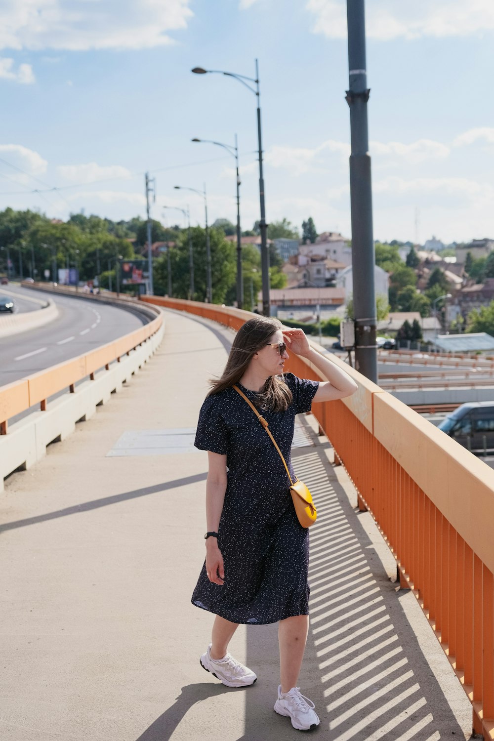 a woman standing on a bridge looking at the sky